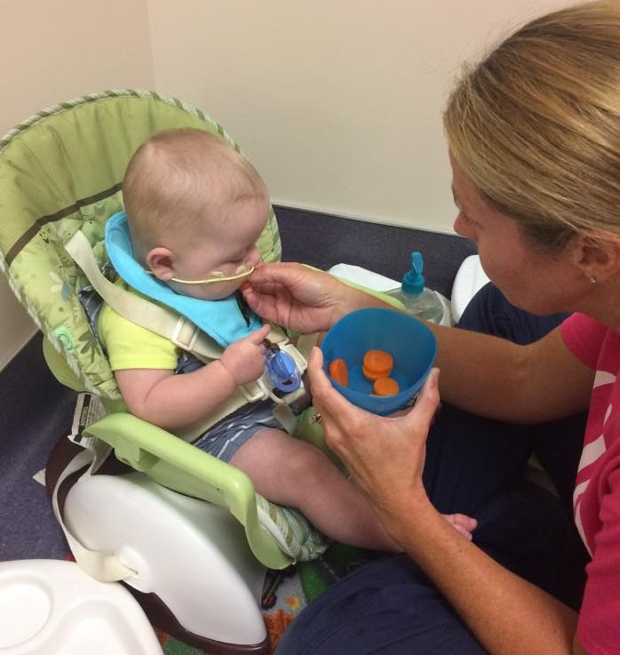 Baby with CHD trying a carrot at feeding therapy.