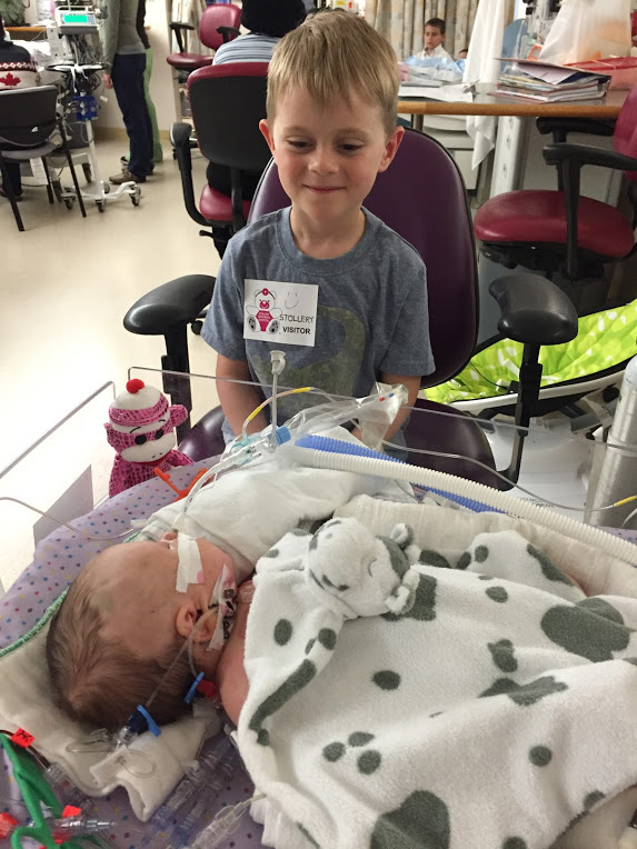 Sibling's first glimpse at his sister in the NICU as she prepares for heart surgery.