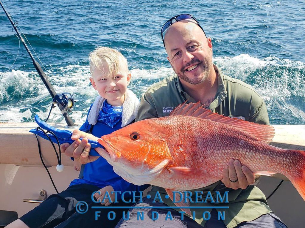 Little boy fishing on his dream trip from a charity organization for children with critical illness.
